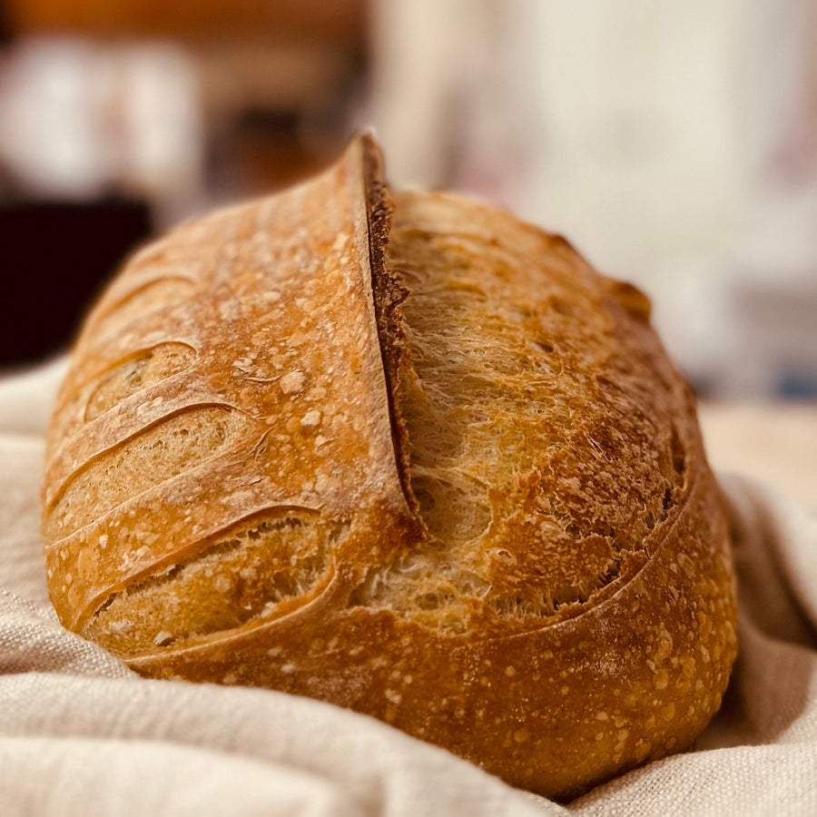 Close view of the crisp golden crust on a Stirred By God artisan sourdough loaf