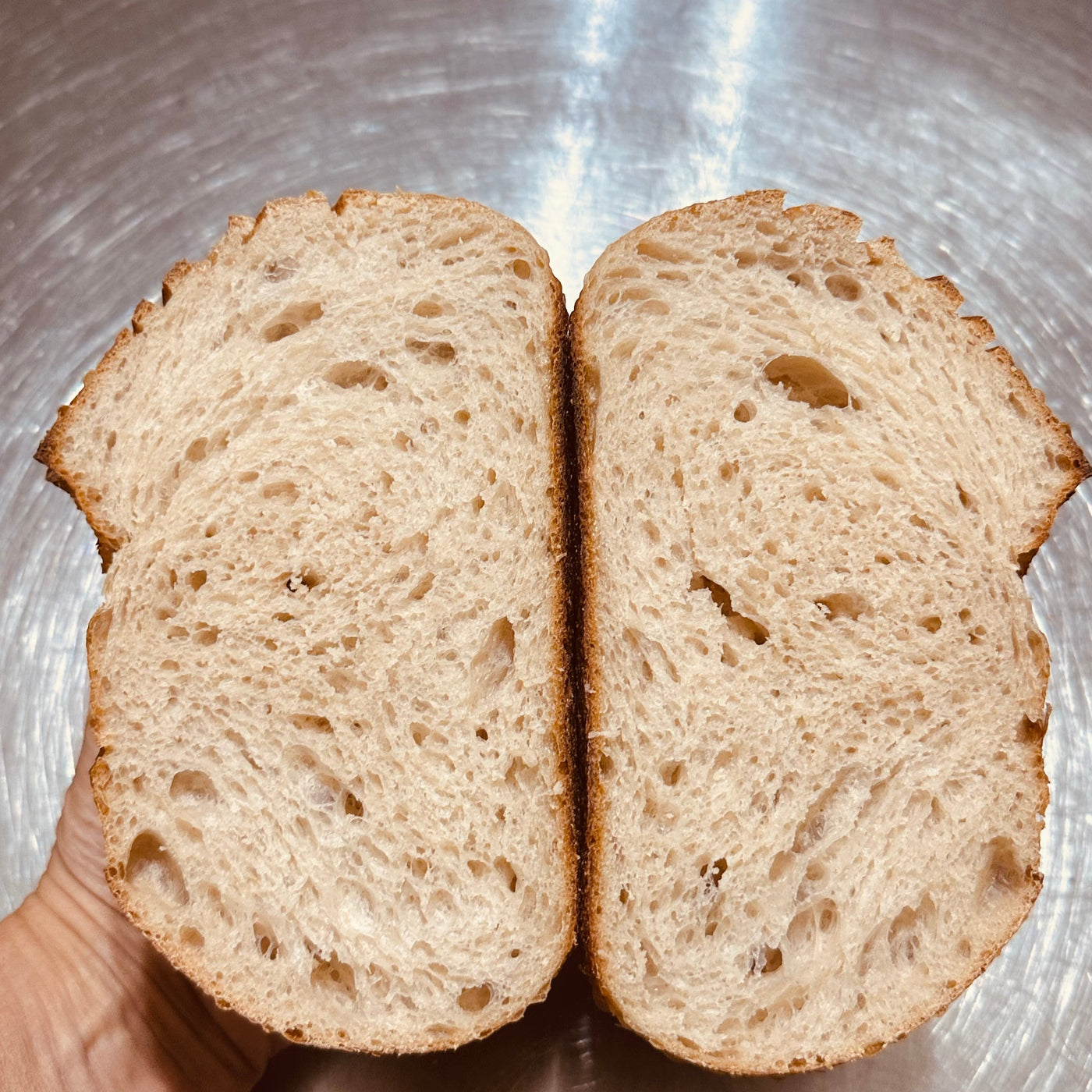 Country sourdough loaf opened to show its soft artisan crumb